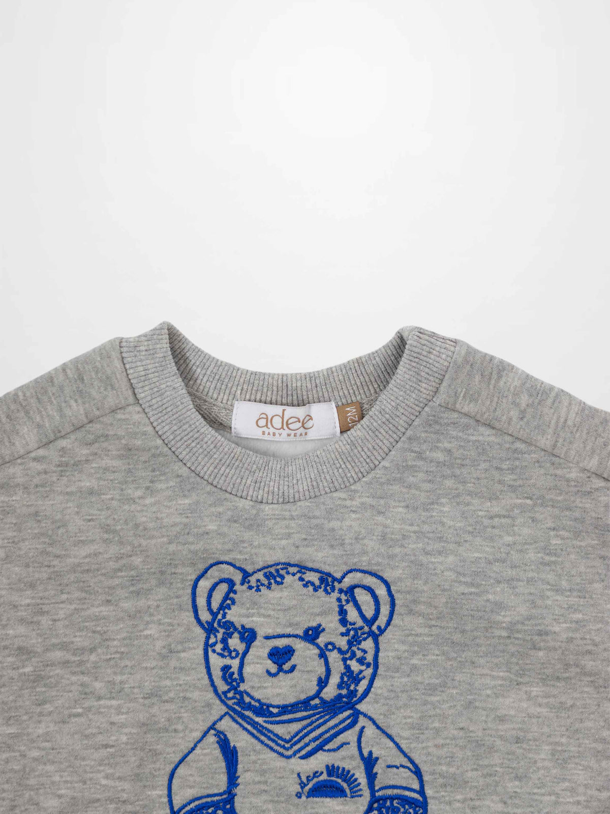 Grey sweatshirt for boys with bold blue teddy bear embroidery.