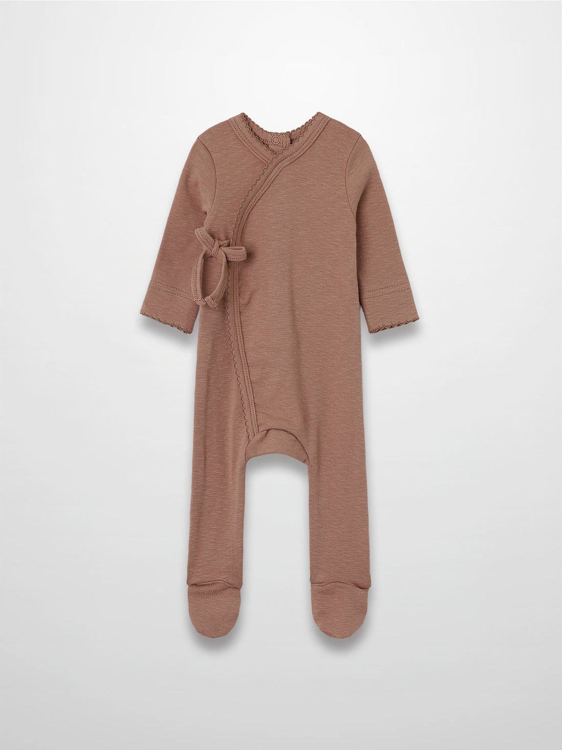 Dusty pink stretchy baby girl jumpsuit footie with side wrap crossover and scalloped trim.