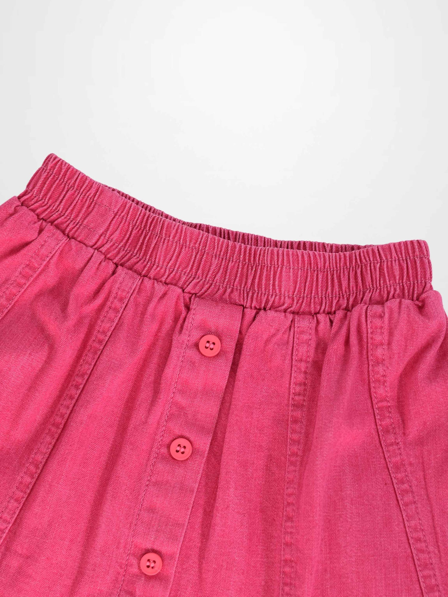 Paneled pink denim skirt with elastic waistband and pink front buttons.