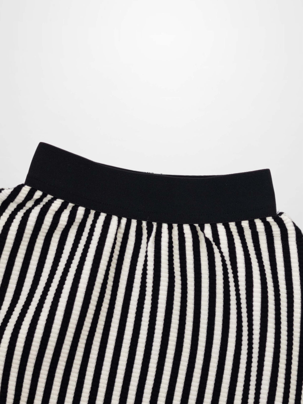 Vertical black and white striped circle skirt with ribbed texture and a wide black elastic waistband.