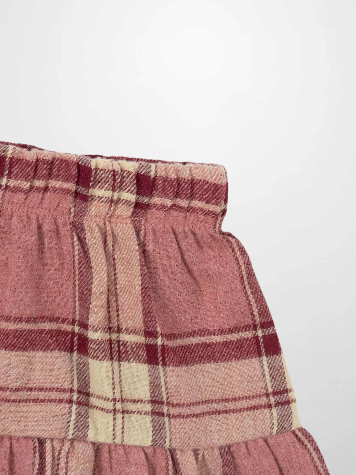 Adee plaid skirt for girls in pink and deep red plaid with an elastic gathered waistband.