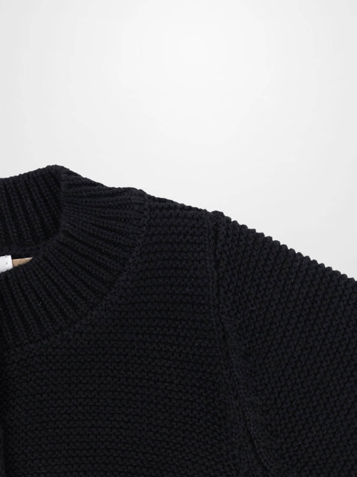 Cropped black cardigan in chunky knit with a ribbed collar; unisex dressy knit top.