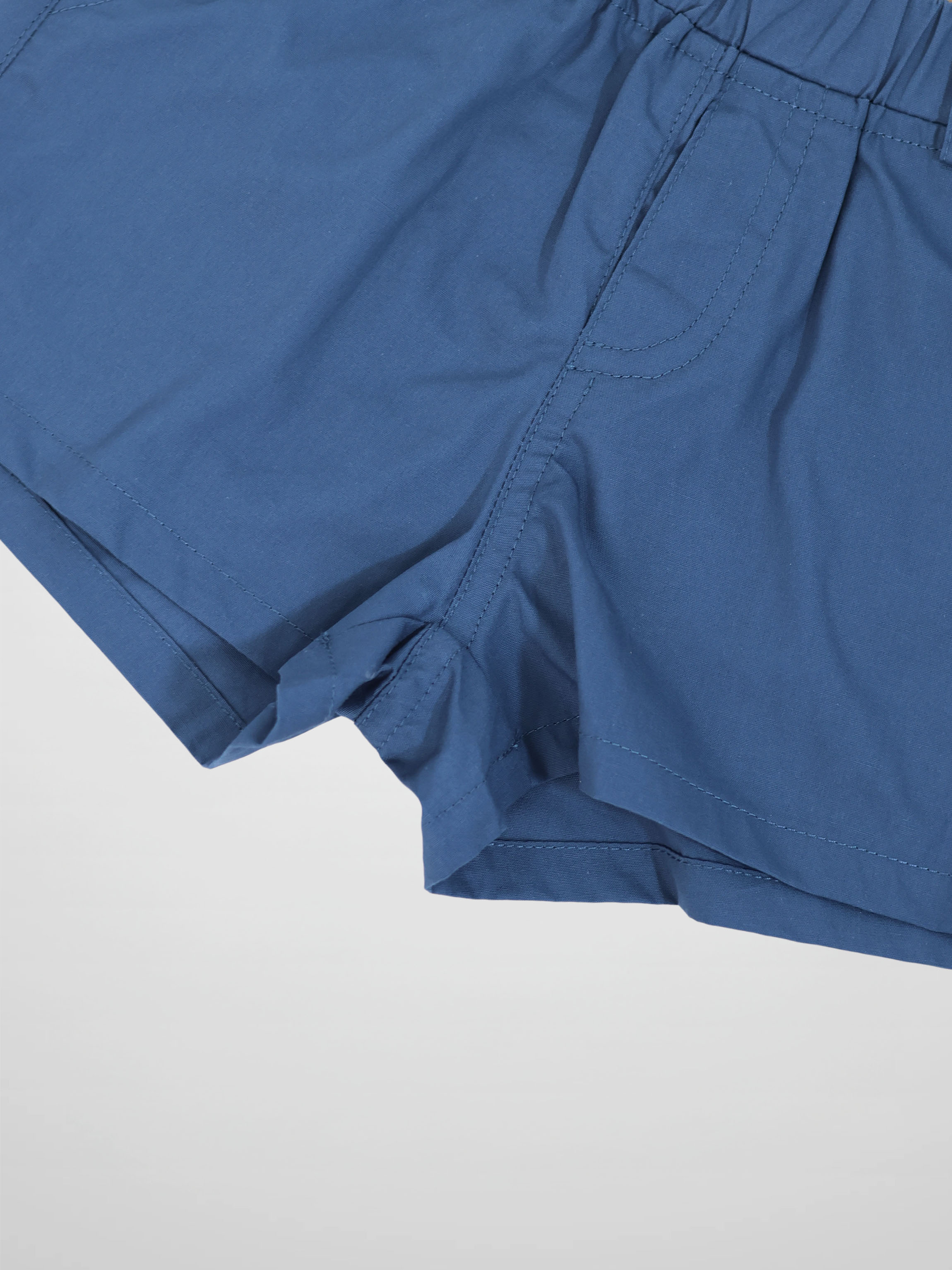 Blue cotton shorts with elastic waistband, side pocket, and reinforced seams.