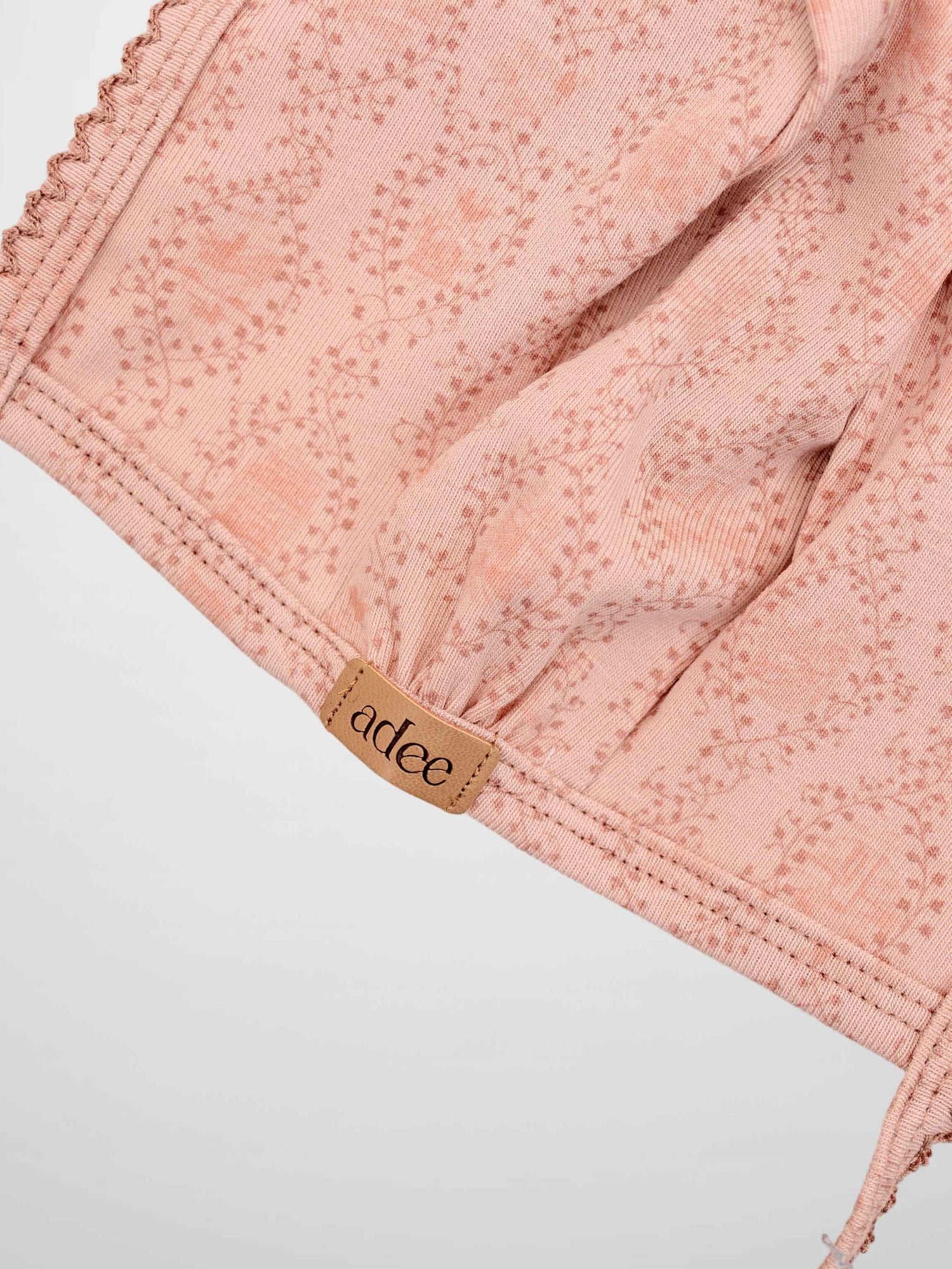 Pink Charm Bonnet by Adee with trailing vine and leaf motif