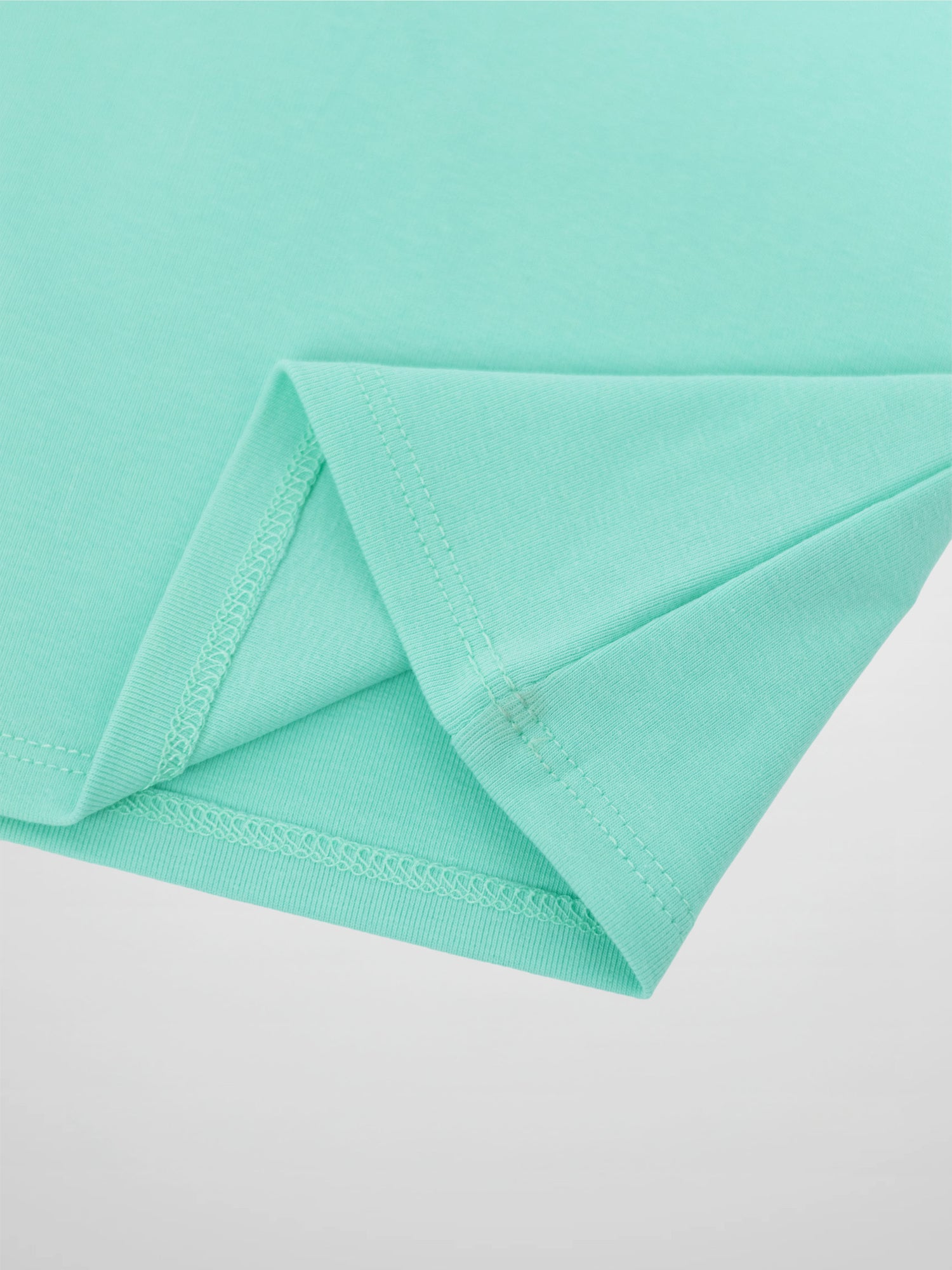 Mint green 3/4 puff sleeve T-shirt fabric close-up with folded hem.