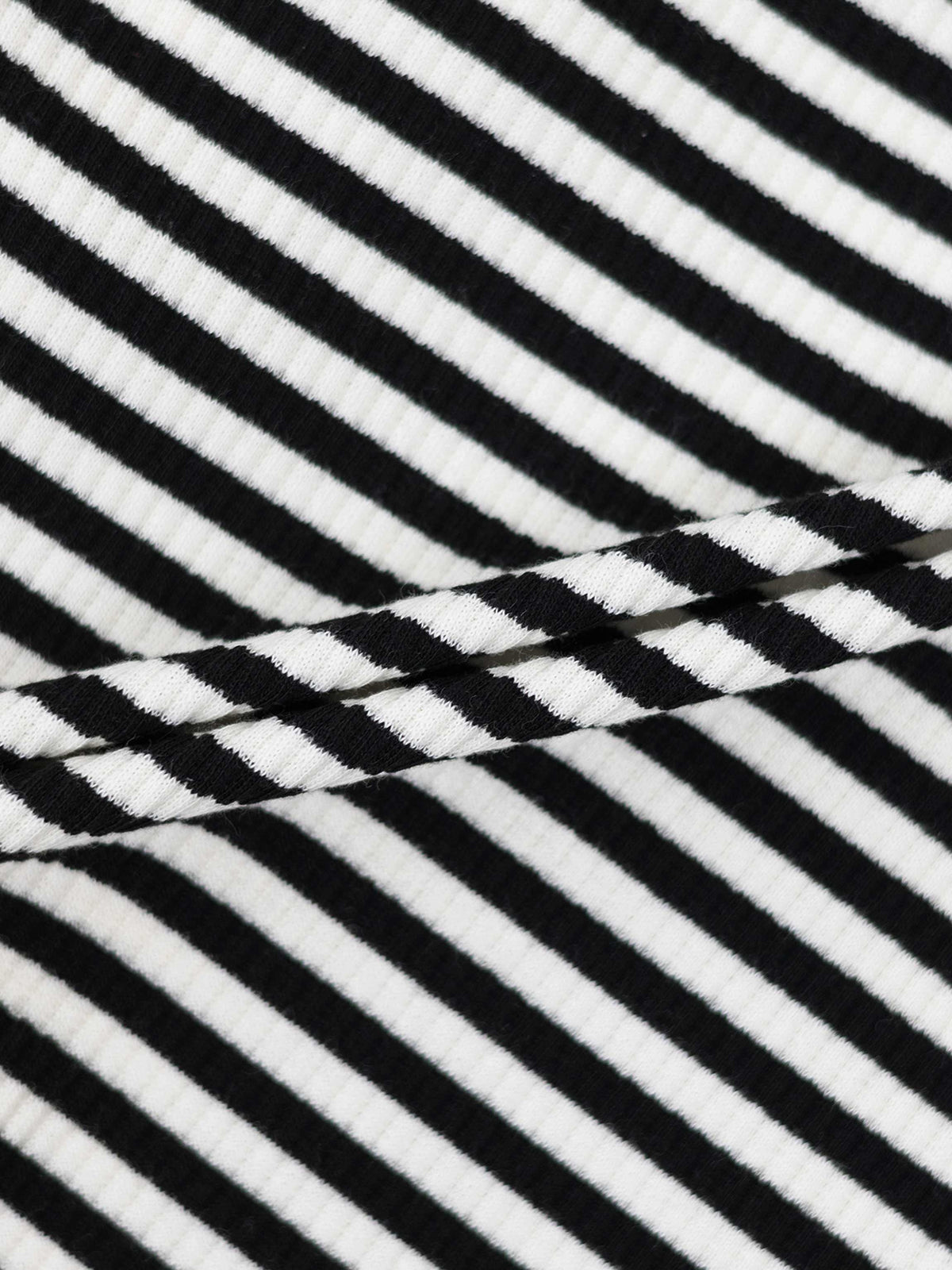 Close-up of black and white striped ribbed fabric for a circle skirt with a wide black elastic waist.