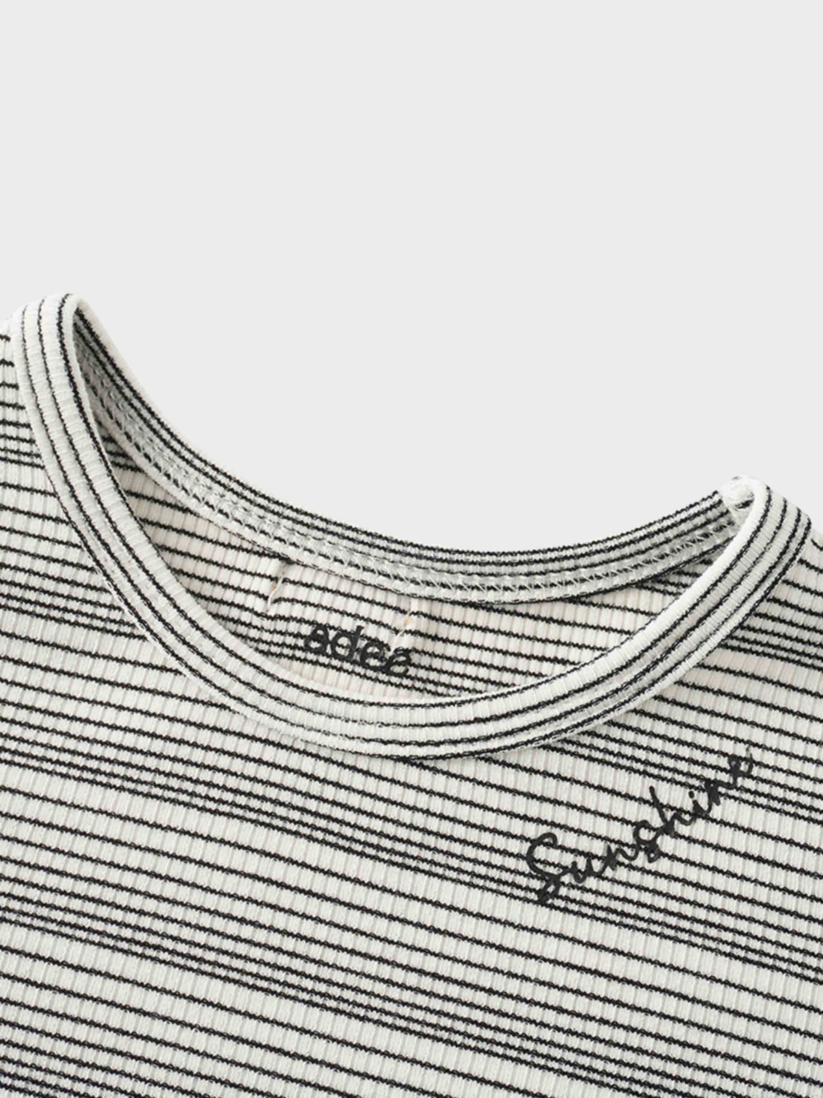 Textured white knit tee with thin black stripes, fitted 3/4 sleeves, and &