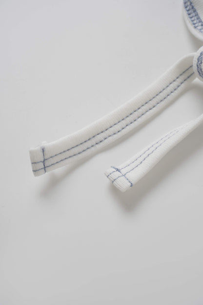 Mini Gallery Bonnet for boys, white fabric with blue stitching on the ties