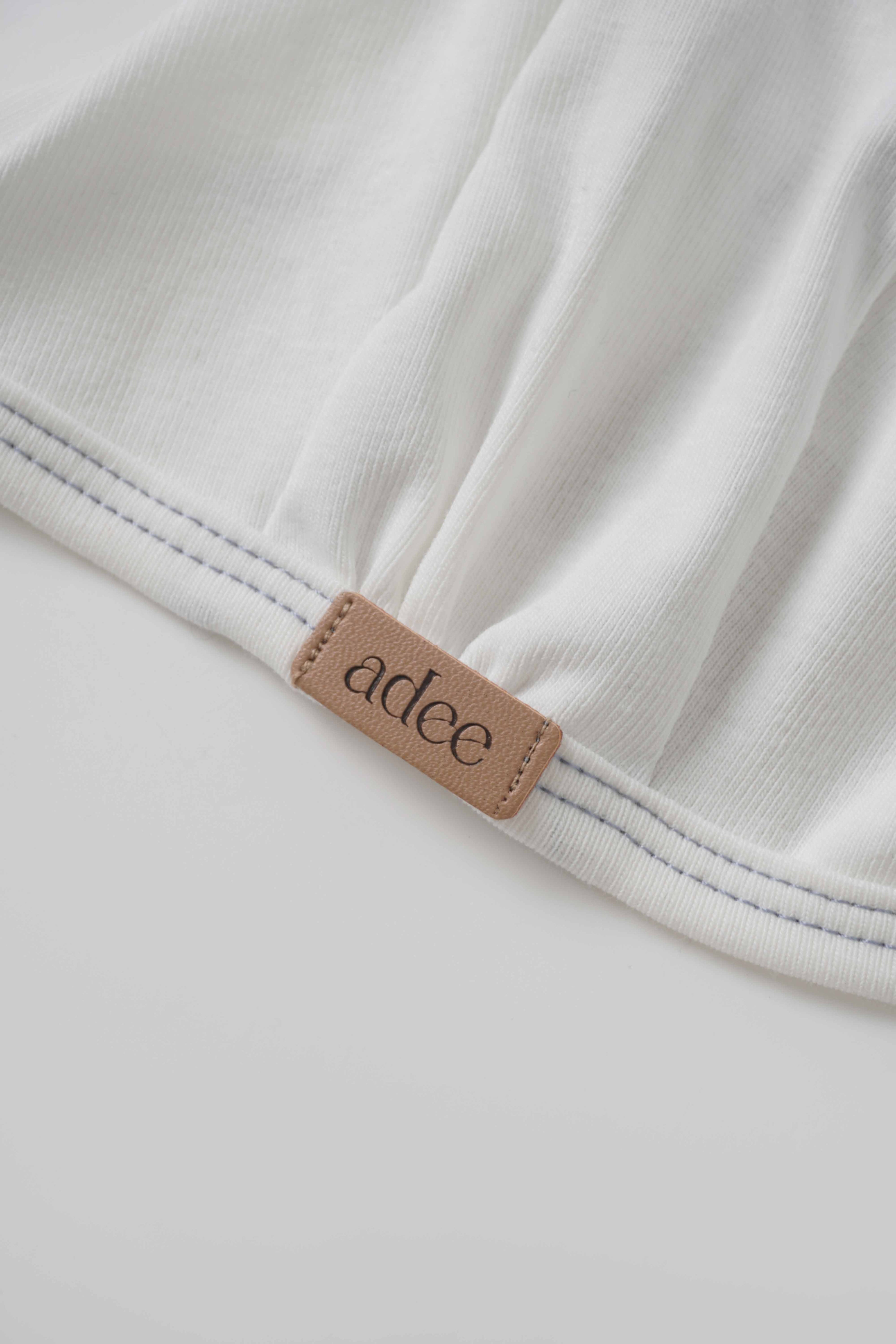 Mini Gallery Bonnet for boys by Adee; white fabric with blue stitching and tan logo patch