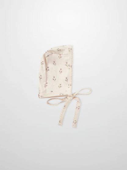 Tiny Tulip Bonnet in cream ribbed fabric with pink floral print and tie strings