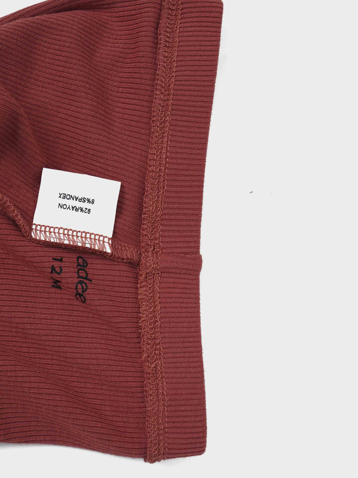 Embossed Mug Sweatshirt &amp; Leggings Set for little girls in rust by Adee; close-up of ribbed fabric and brand tag.
