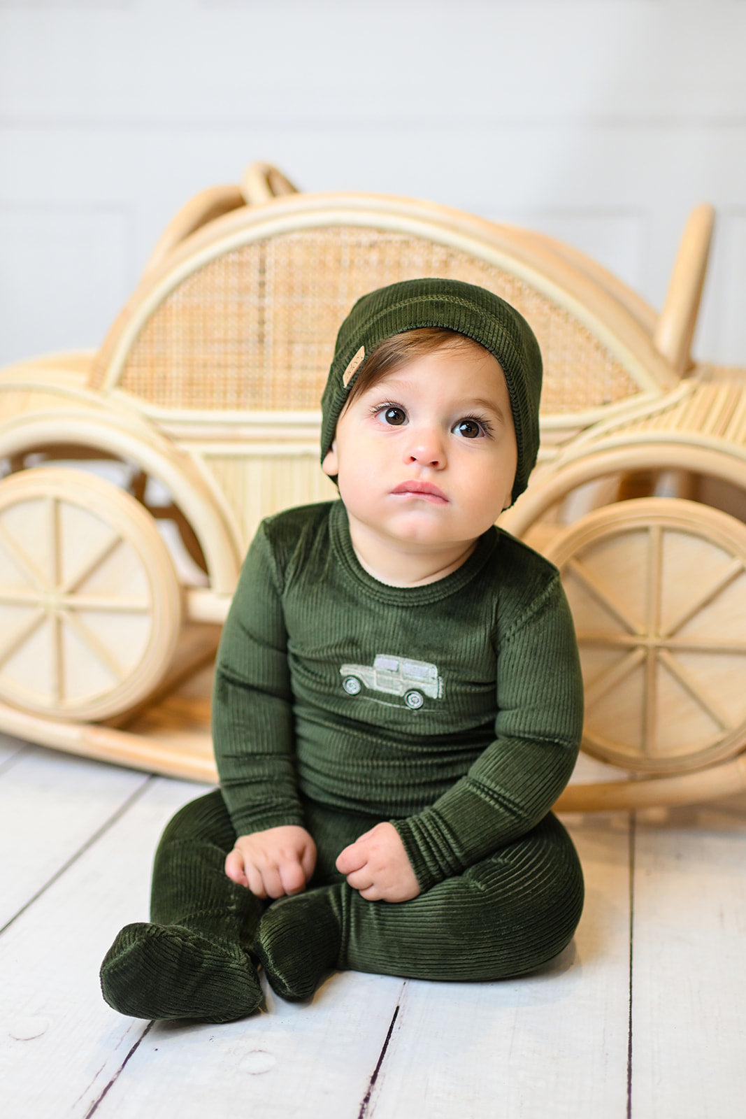 Baby wearing olive green embroidered car beanie with a matching plush velour outfit.