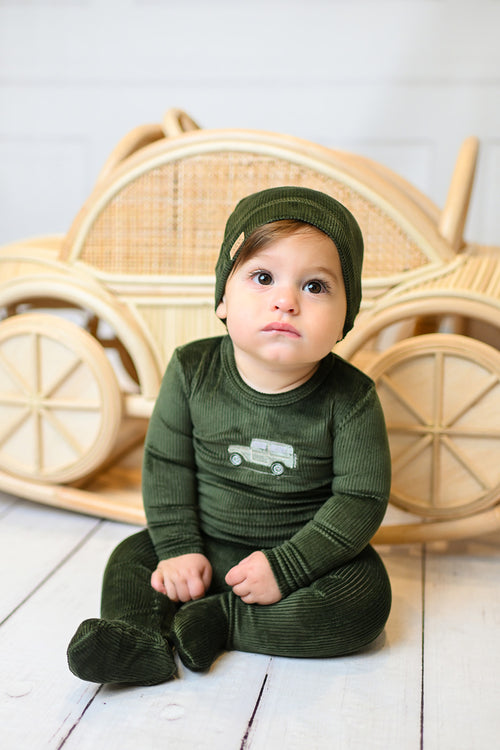 Baby wearing olive green embroidered car beanie with a matching plush velour outfit.