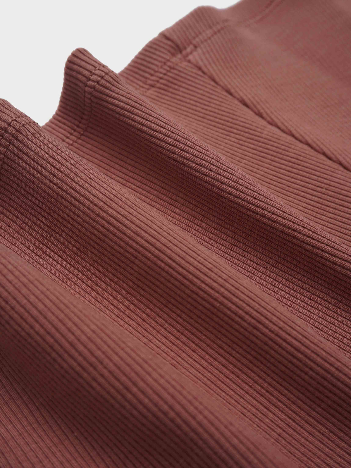 Brick-colored ribbed fabric close-up for Embossed Logo Skirt.