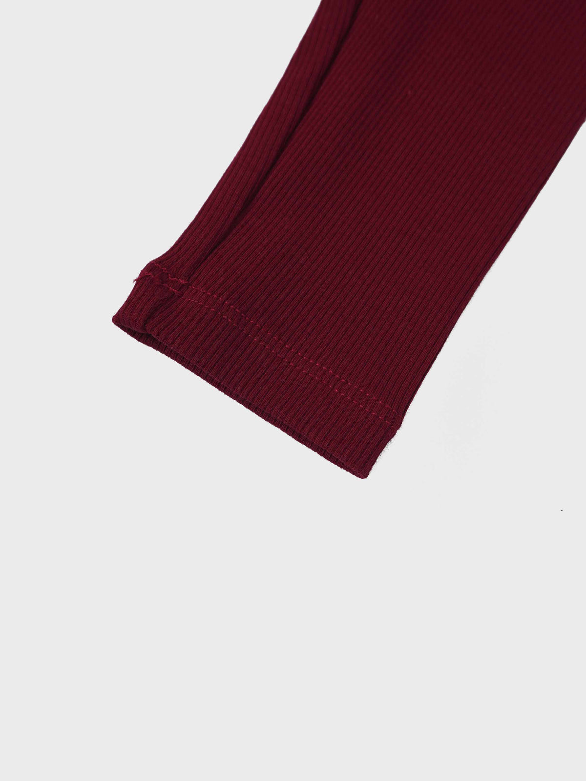 Ribbed burgundy leggings with a stitched cuff hem and thin knit fabric