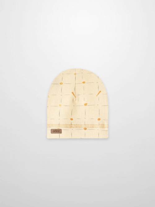 Grand Slam hat for boys by Adee; beige knit beanie with pale blue grid lines and orange dots.