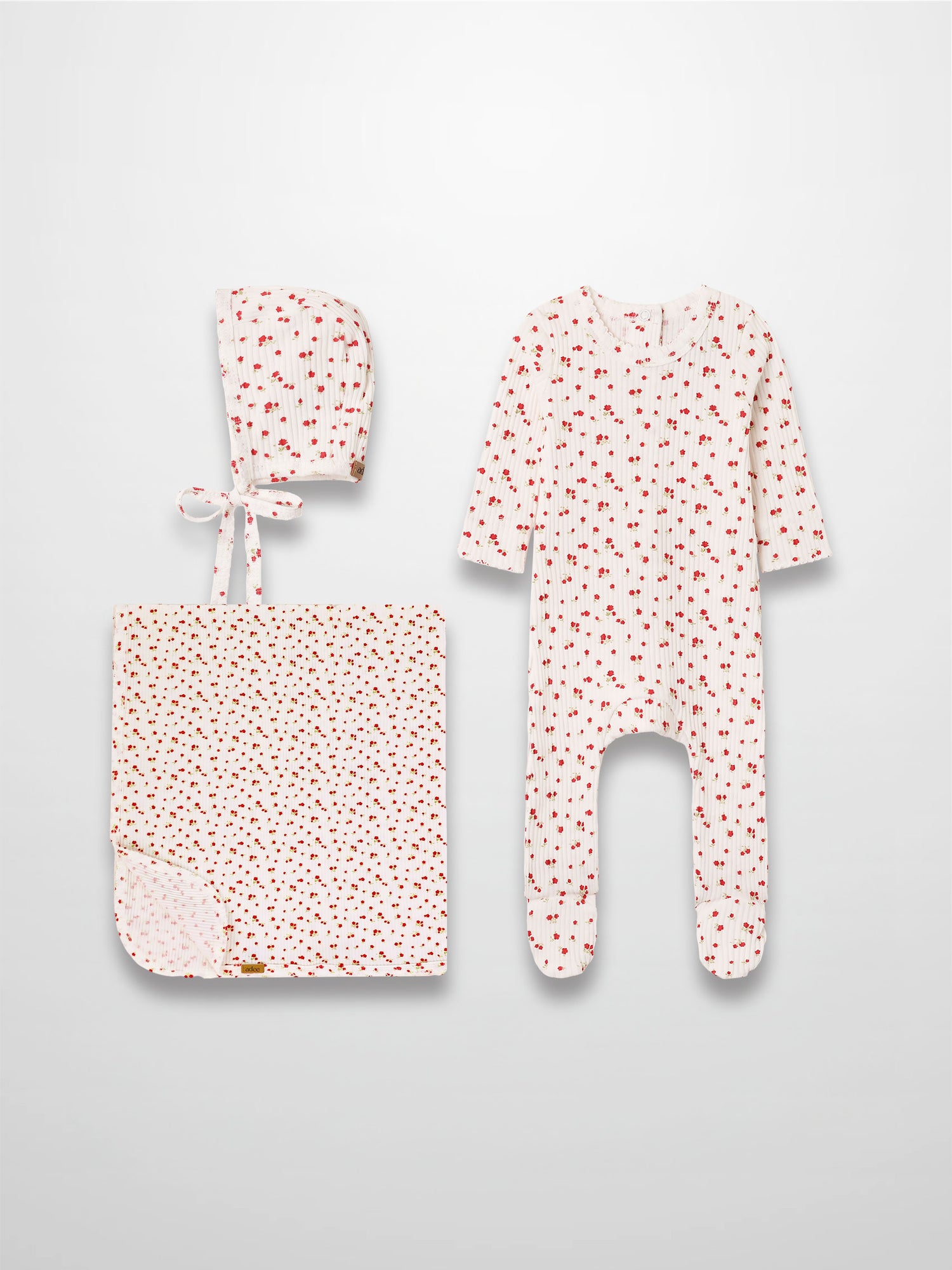 Red Flower layette set for girls by Adee; white fabric with tiny red flowers; includes footed onesie, hat, and blanket.