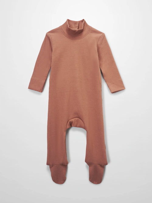 Pink ribbed, footed baby romper with long sleeves and a mock neck.