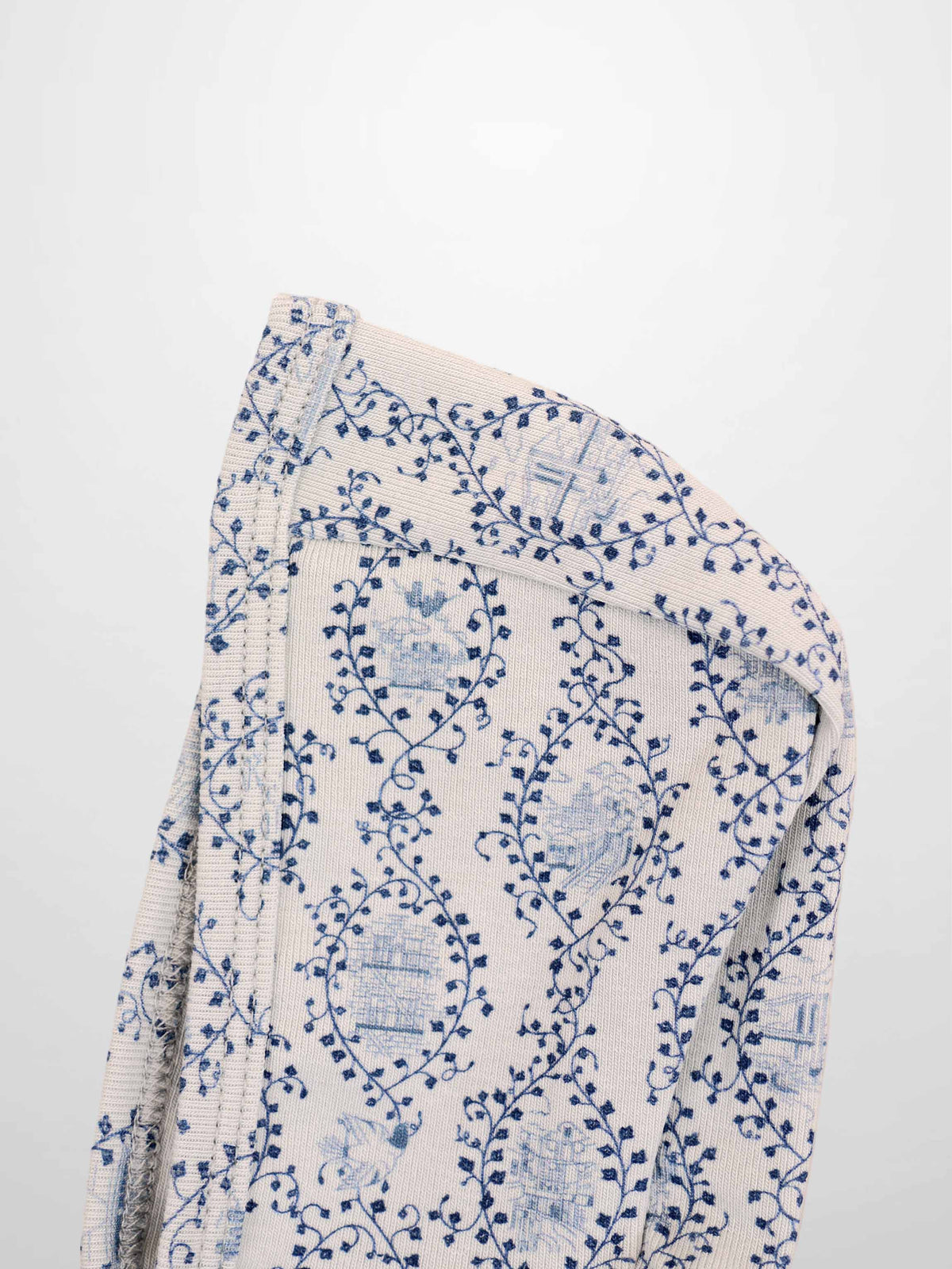 Blue Charm Bonnet for boys by Adee; beige knit fabric with dark blue vine pattern.