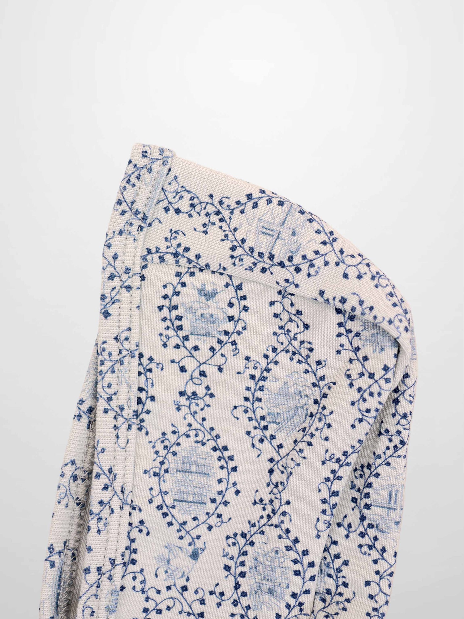 Blue Charm Bonnet for boys by Adee; beige knit fabric with dark blue vine pattern.