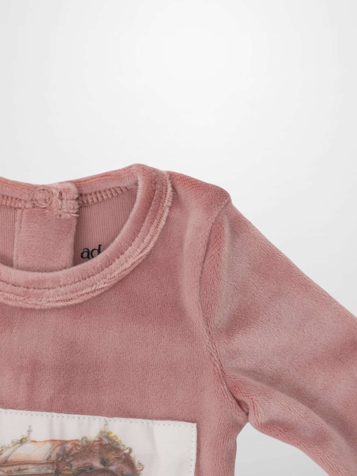 Velour Carriage Stretchy pink baby footie with vintage carriage embroidery on a fabric patch.