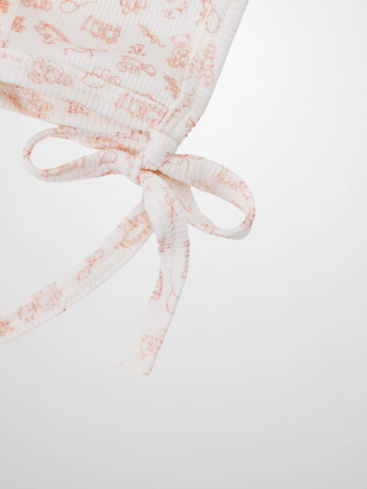 Little Storybook Bonnet Pink; white ribbed knit baby bonnet with pink print and tied ribbons