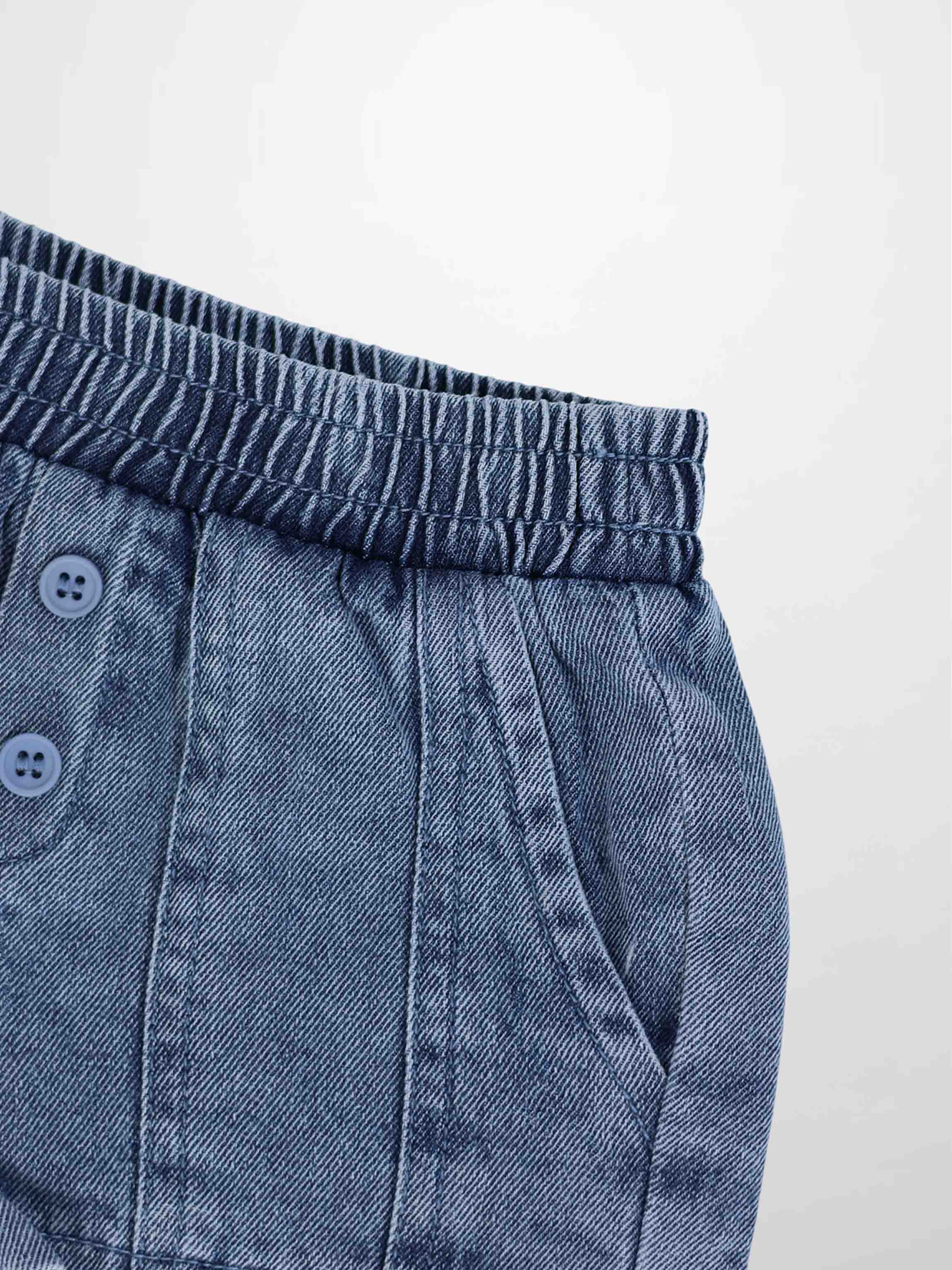 Paneled Shorts blue denim with elastic waistband and button detail.