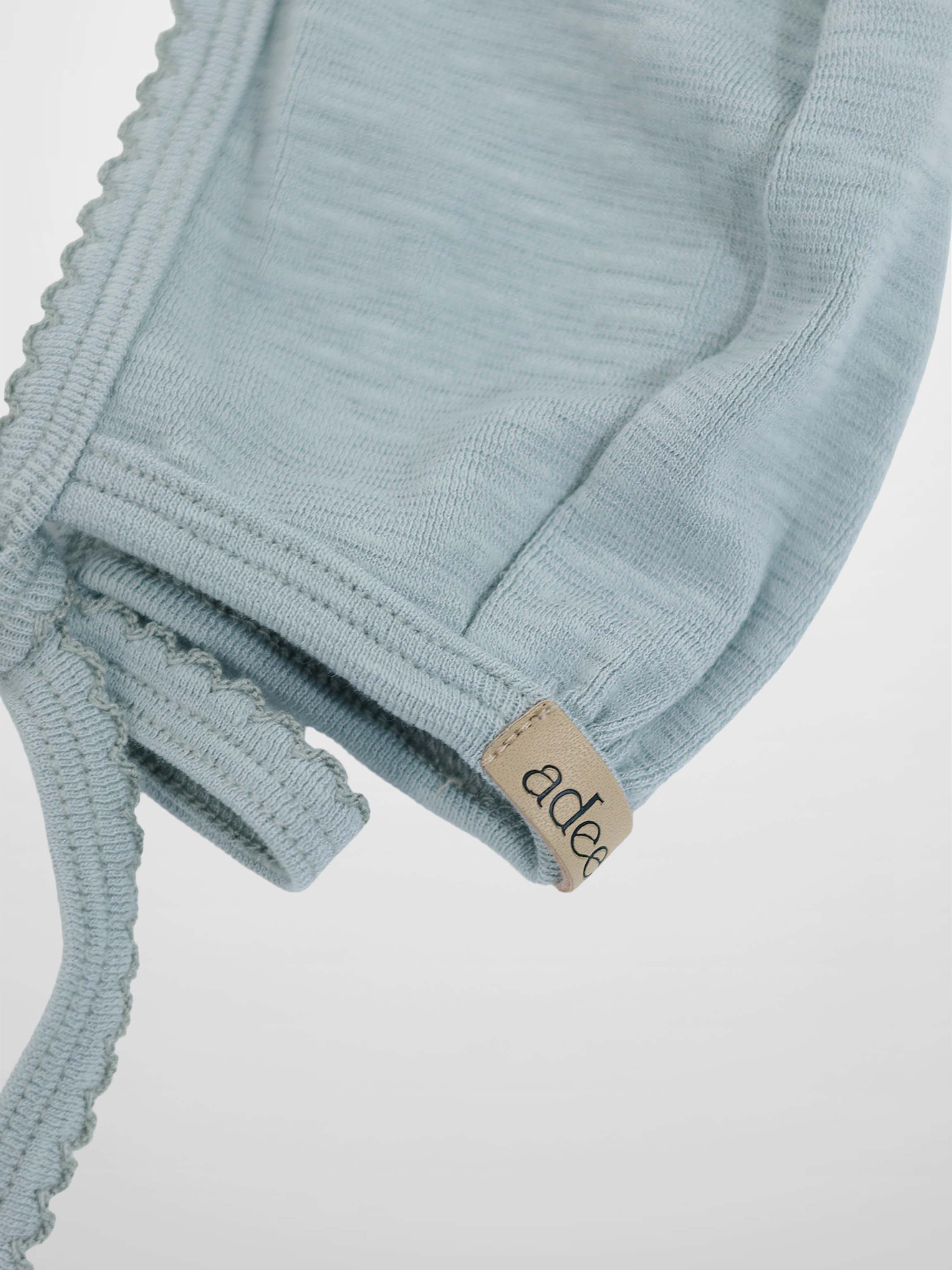 Light blue Adee boys bonnet in soft knit with scalloped trim