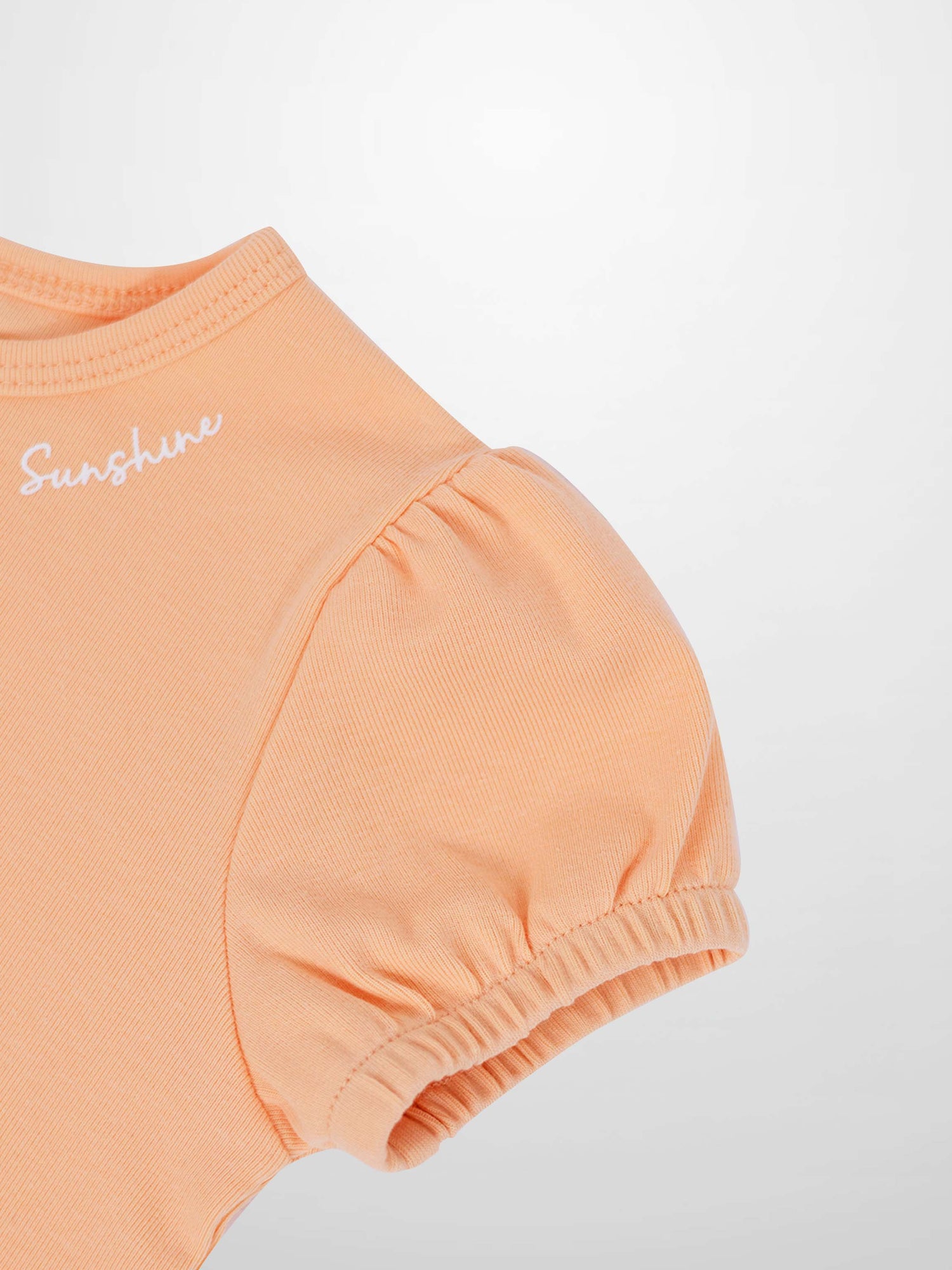 Adee girls Short Puff Sleeve T-shirt in peach, cotton knit with gathered shoulders and elastic puff sleeves.