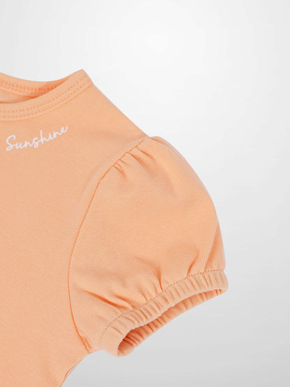 Adee girls Short Puff Sleeve T-shirt in peach, cotton knit with gathered shoulders and elastic puff sleeves.