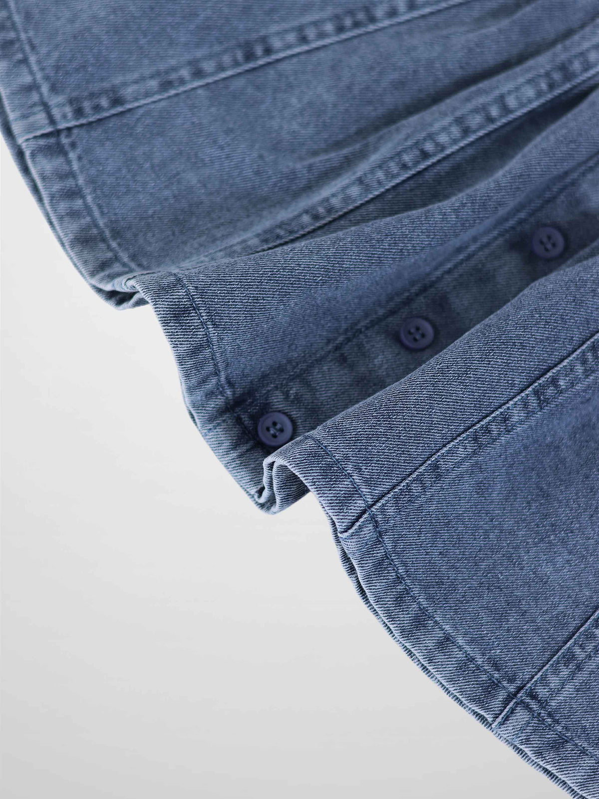 Paneled Skirt - Blue Denim; close-up of blue denim fabric with navy buttons