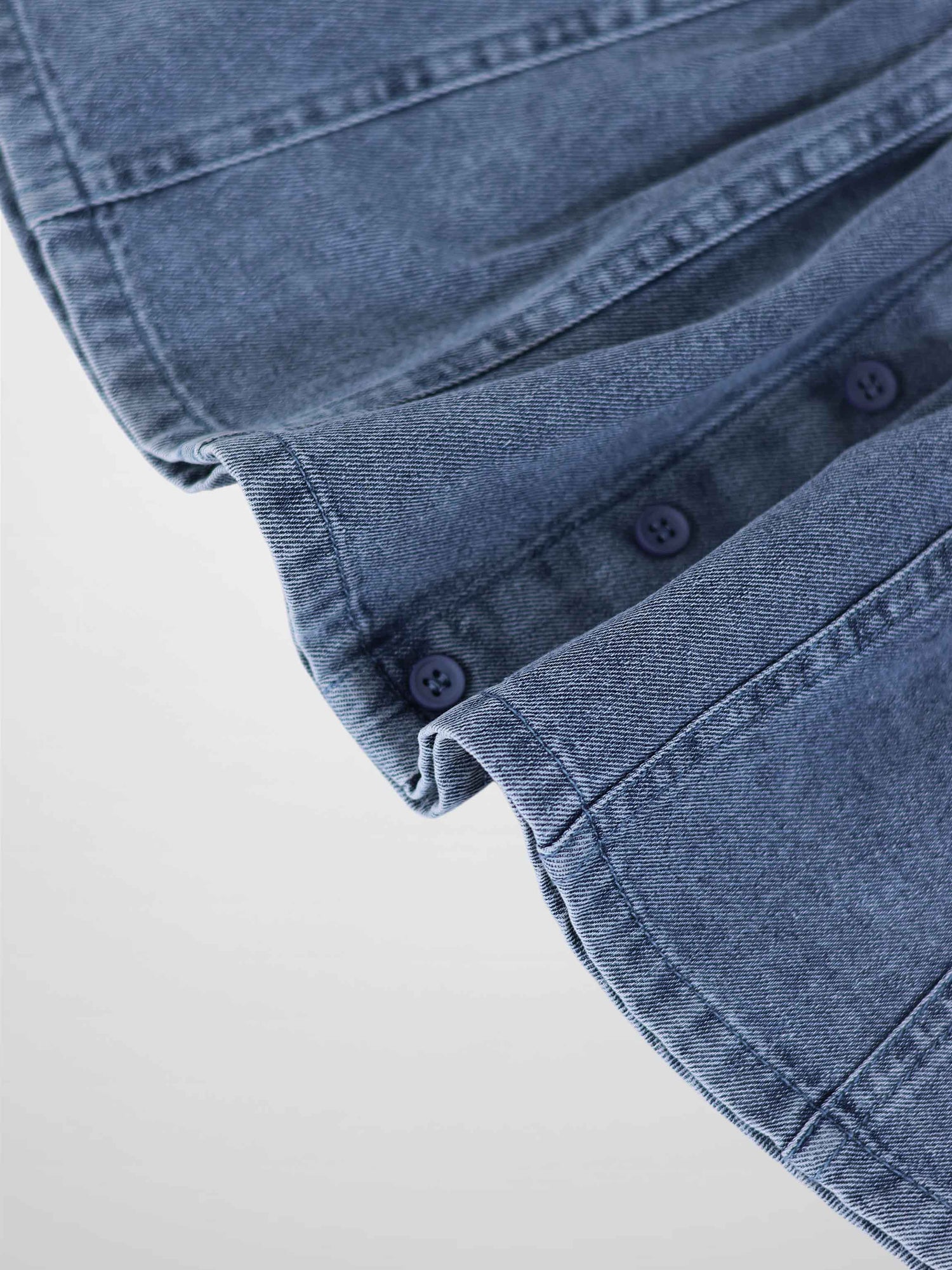 Paneled Skirt - Blue Denim; close-up of blue denim fabric with navy buttons