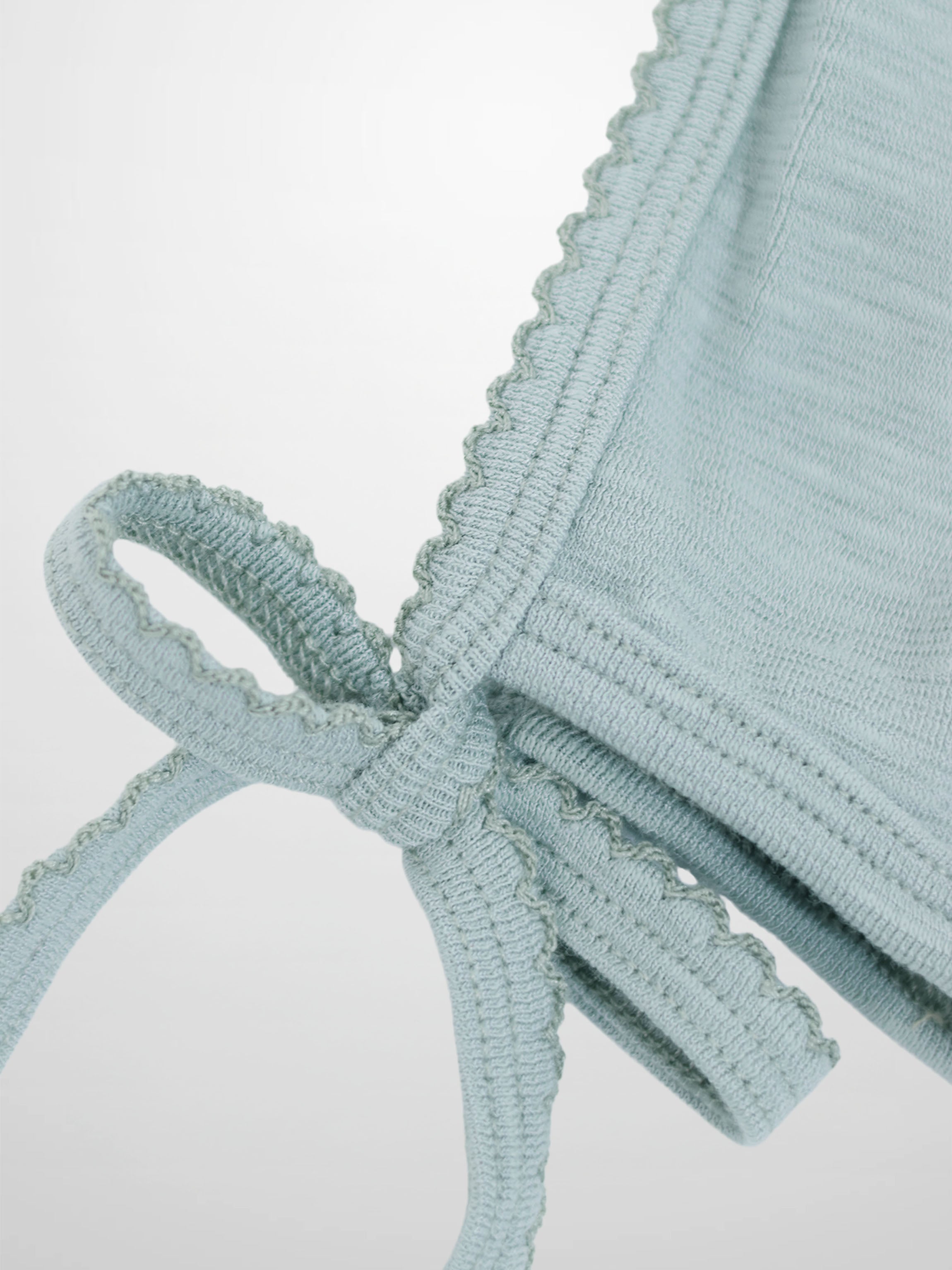 Blue scalloped bonnet for boys by Adee, soft light-blue knit with tied strings.