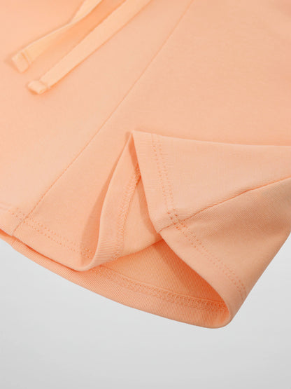 Adee 6 Panel Skirt for girls in peach, close-up of peach fabric, visible stitched hem and waistband drawstrings.