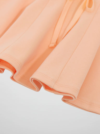 6-panel peach skirt fabric close-up with folded panels and neat hems