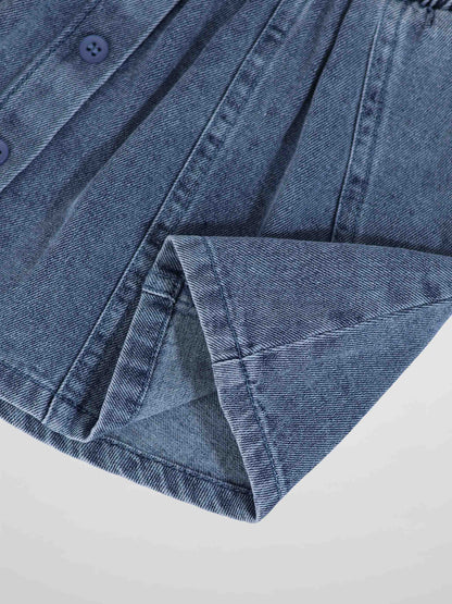 Paneled blue denim fabric with button placket and folded cuff detail.