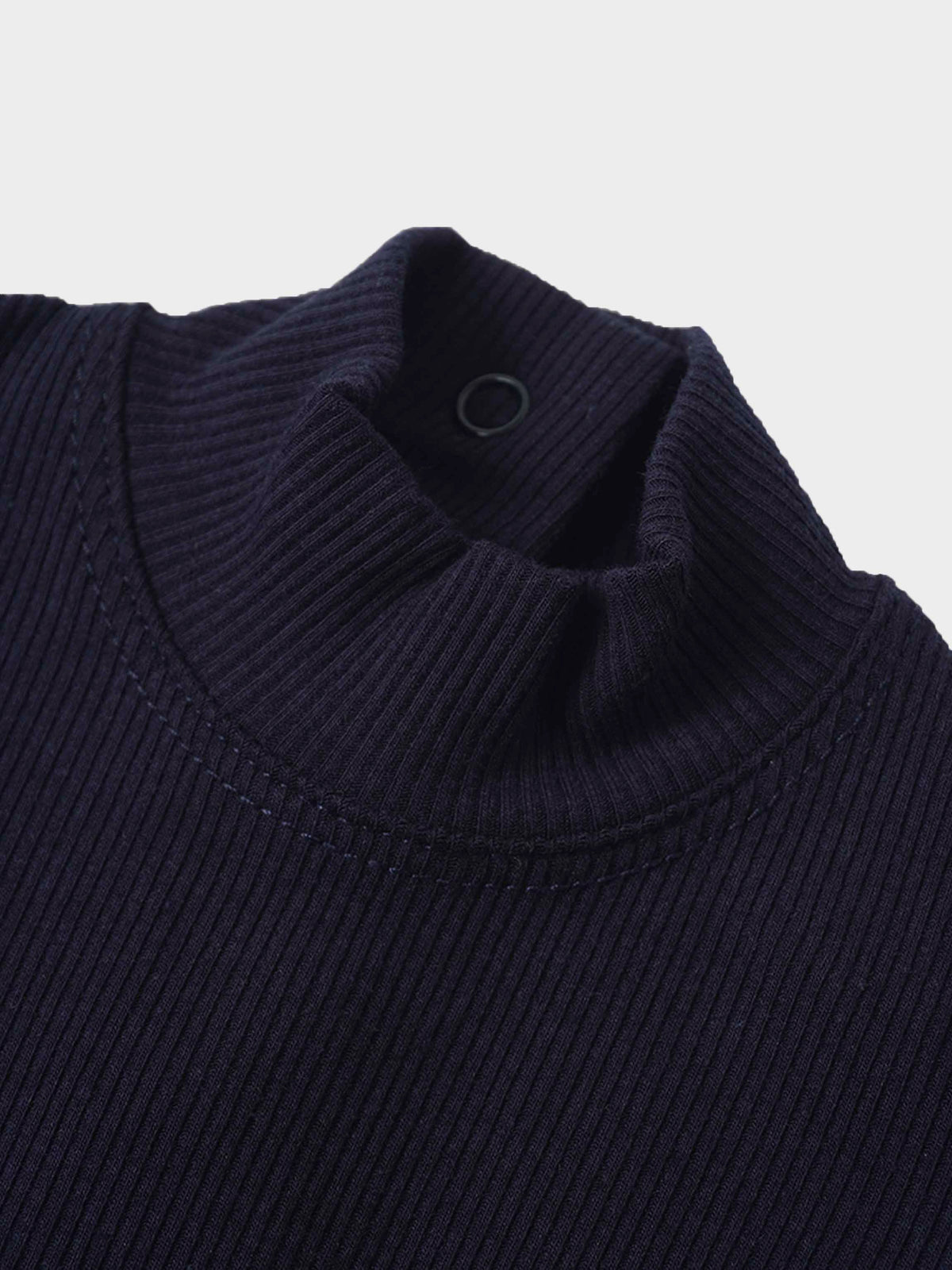 Close-up of navy ribbed mock-neck collar on baby boy footie.