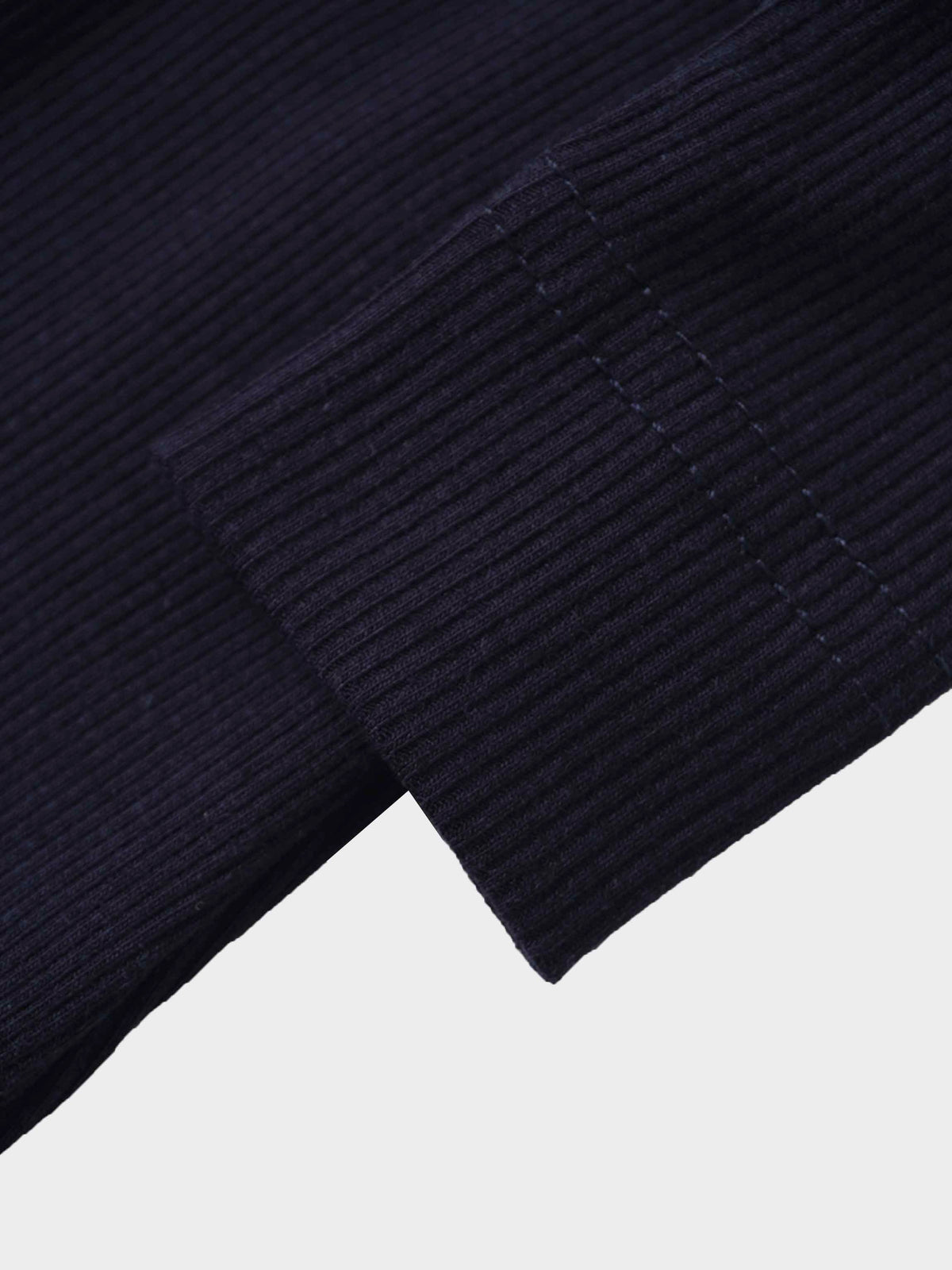 Close-up of navy ribbed knit cuff on a stretchy baby footie.