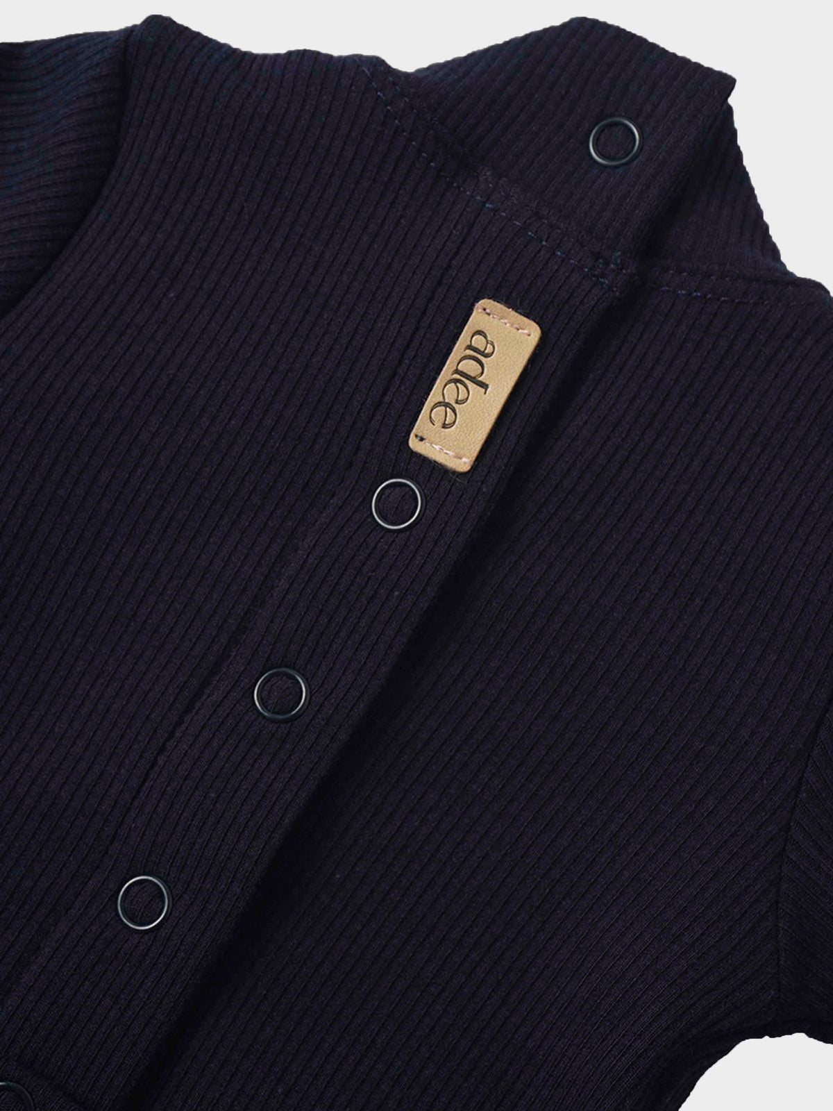 Navy ribbed baby footie with mock neck, stretchy fabric, metal rings along front placket, leather brand tag