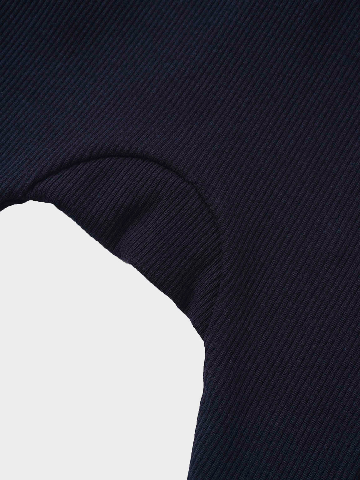 Navy ribbed knit fabric with a curved seam and mock neck detail on a baby garment.