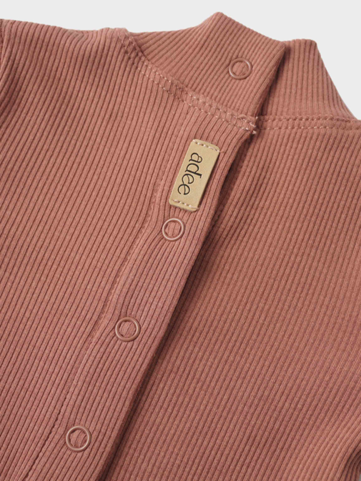 Pink ribbed baby footie with a mock neck and snap button placket, beige brand tag visible.