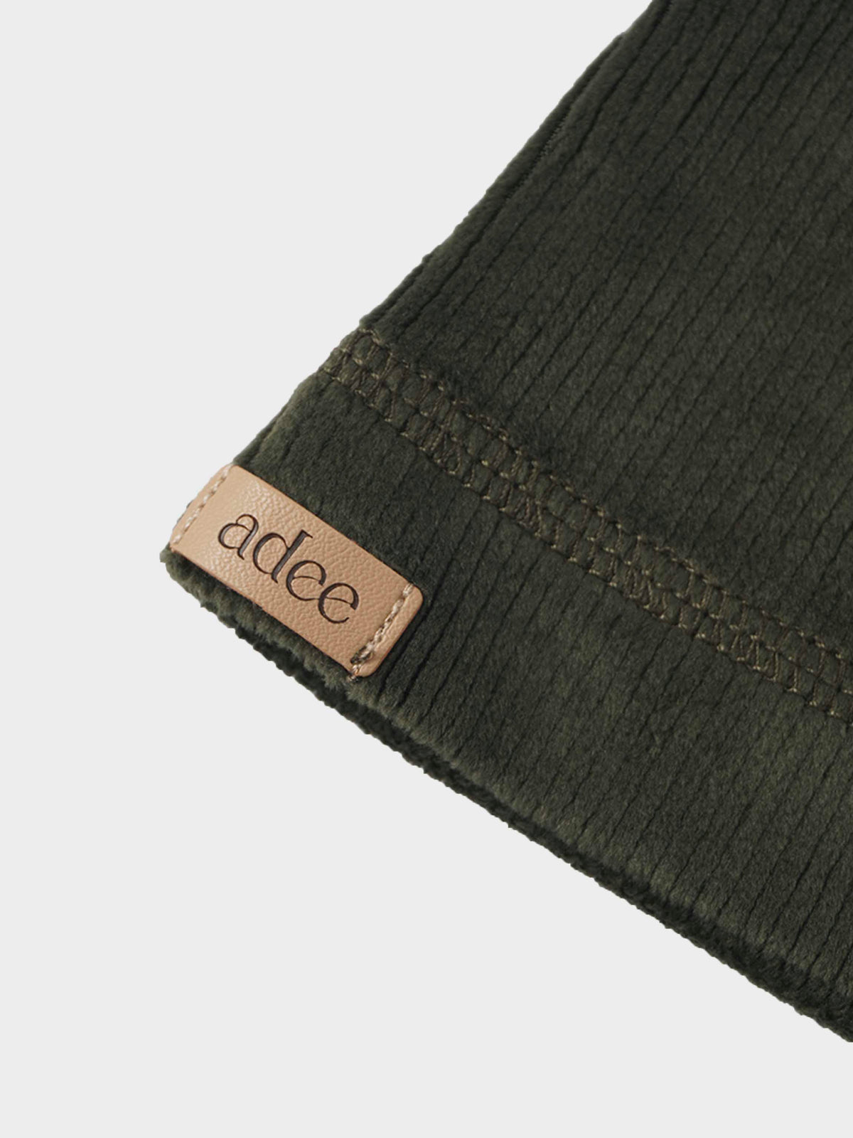Embroidered Car Beanie in olive green plush ribbed velour with decorative stitching and tan leather label.
