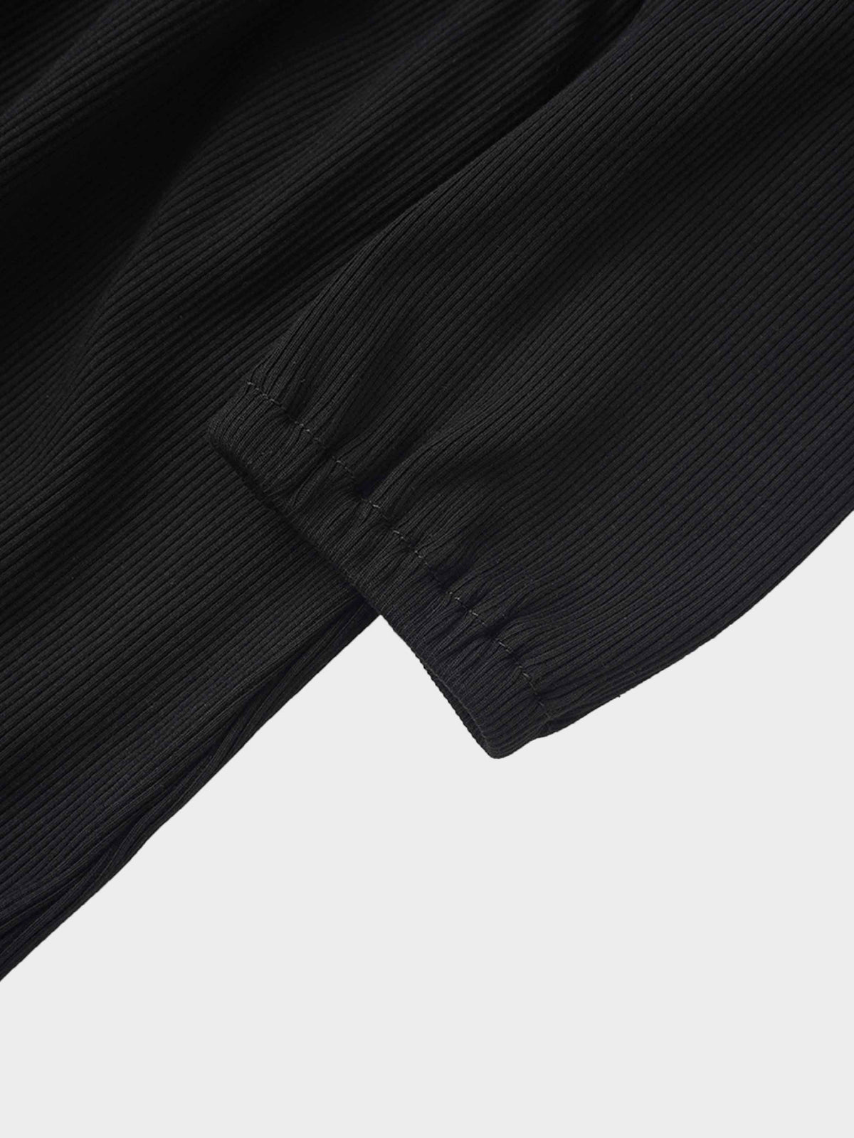 Close-up of black ribbed sleeve with elastic cuff from the Ruffle V Robe.
