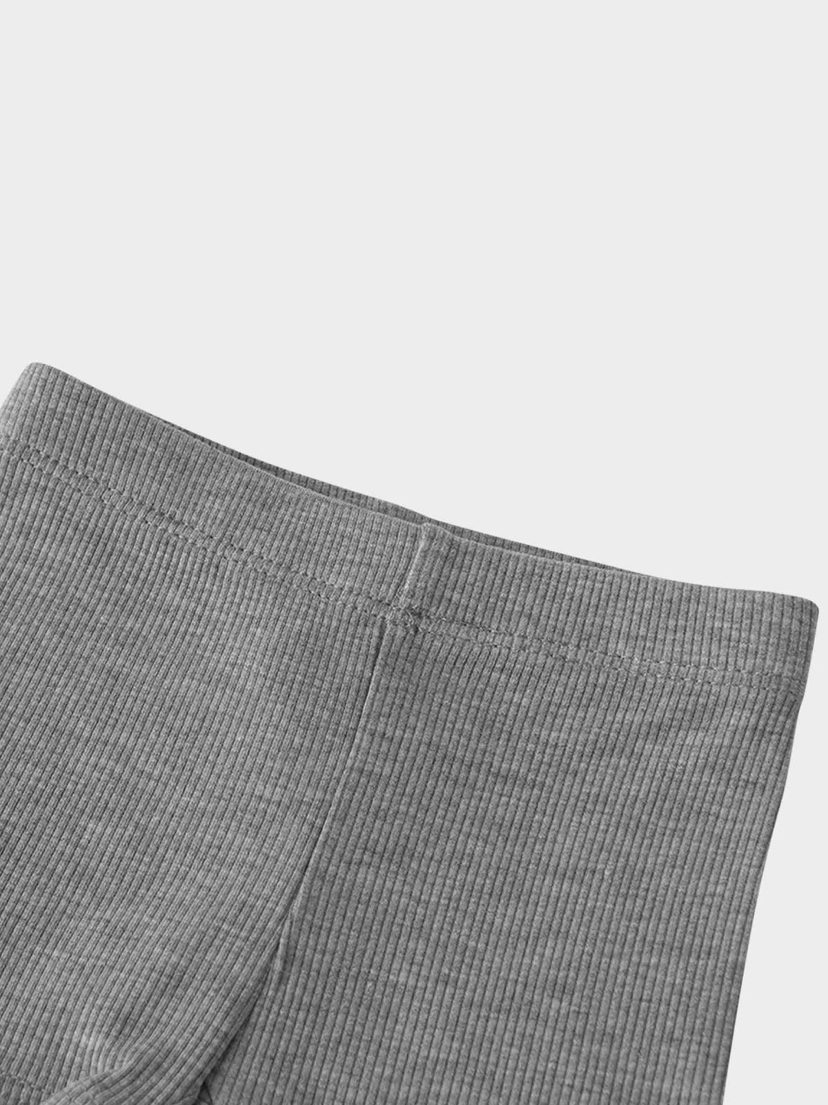 Close-up of grey thin-ribbed fabric and elastic waistband on baby/toddler biker shorts.