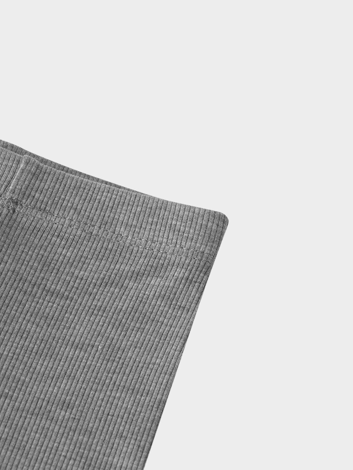 Close-up of light grey thin-ribbed fabric from baby/toddler biker shorts with elastic waistband.