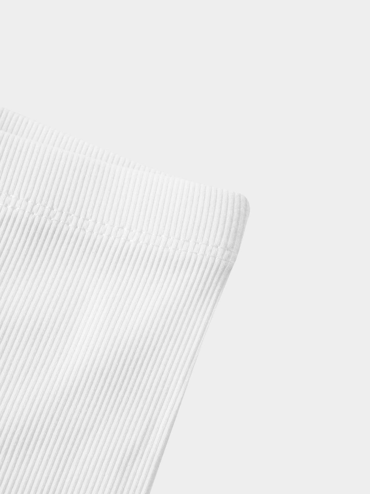 Biker shorts thin ribbed white fabric; close-up texture.