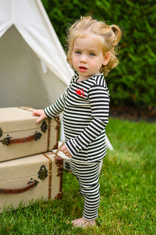 Striped legging set in black and white; unisex toddler apparel photographed outdoors.