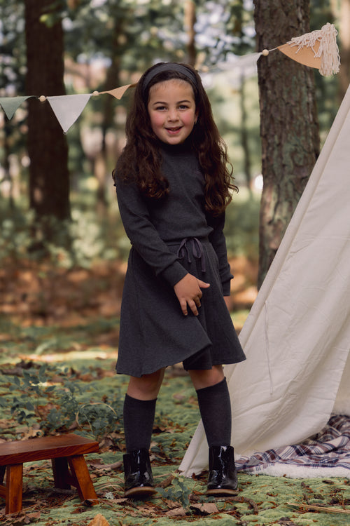 cute and pretty girl wearing a top with a grey circle skirt and drawstring waistband 