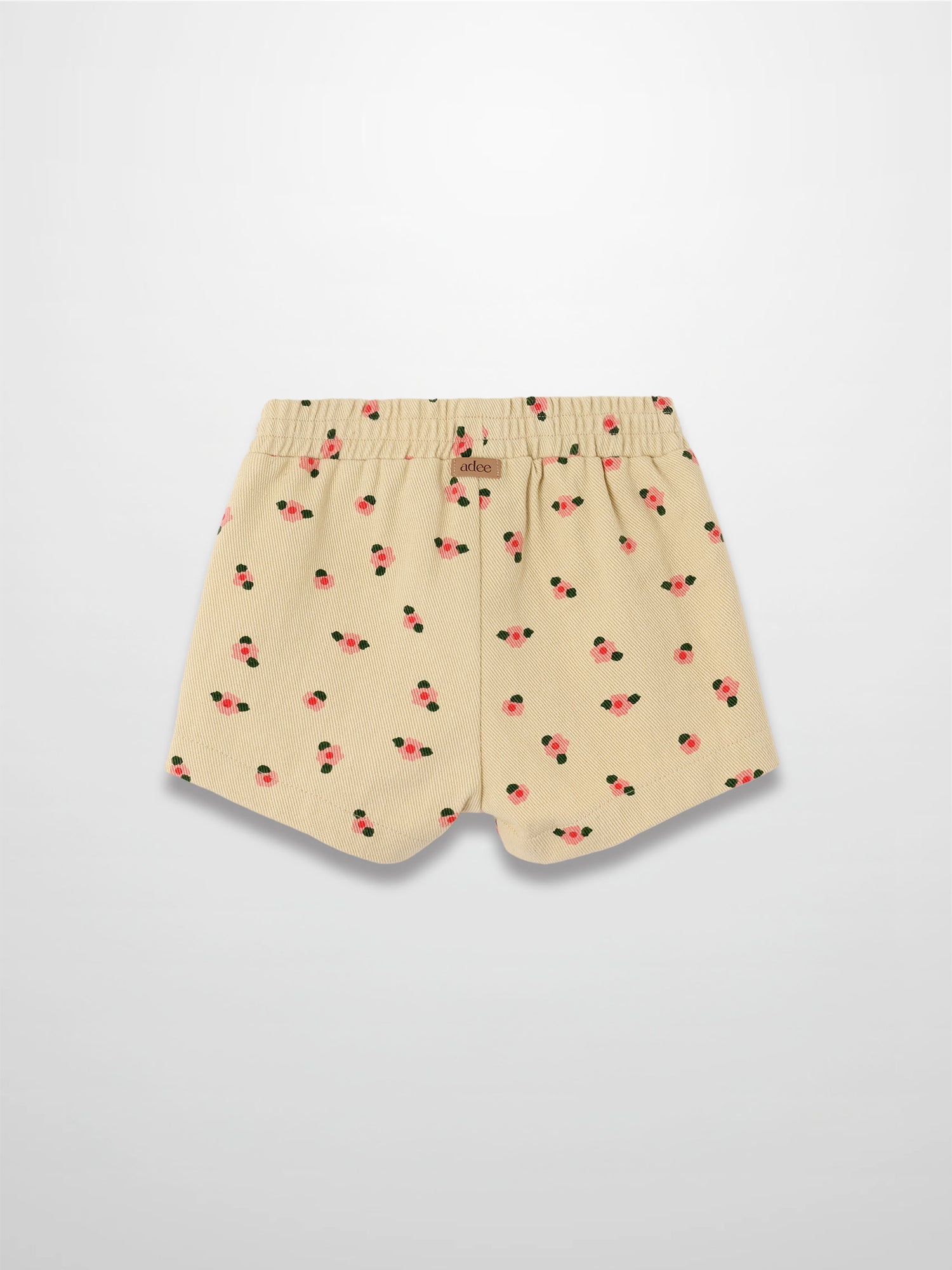 Tan floral shorts with pink blossoms and green leaves, elastic waistband, curved hems.
