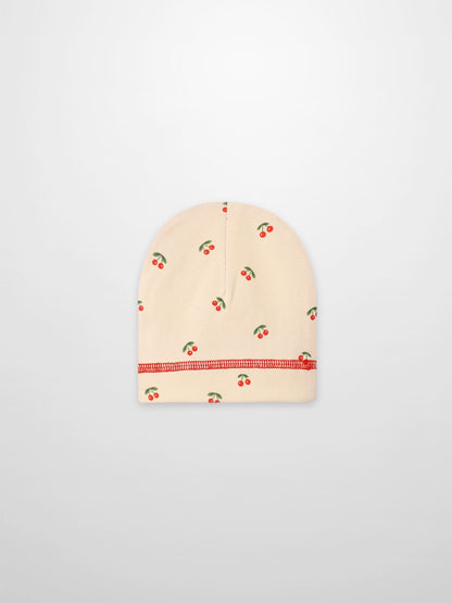 Red Cherry Hat for girls by Adee; beige knit cap with scattered red cherries pattern